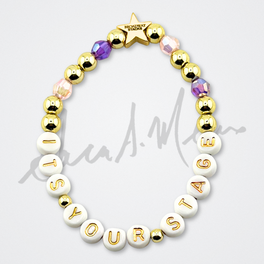 Broadway Stacks Special Edition Sara Mearns STAGE Bracelet Collection. 5 stretch bracelets included in Stack. Purple, pink, clear, white, glitter and gold colored beads. Letter beads that spell quotes. Gold star logo bead to remind you that you shine. Sara Mearns and Ballet fans.