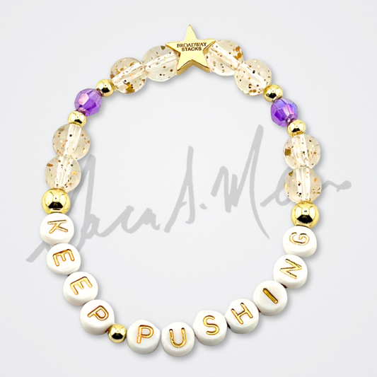 Broadway Stacks Special Edition Sara Mearns STAGE Bracelet Collection. 5 stretch bracelets included in Stack. Purple, pink, clear, white, glitter and gold colored beads. Letter beads that spell quotes. Gold star logo bead to remind you that you shine. Sara Mearns NYCB Principal Dancer and Ballet fans.