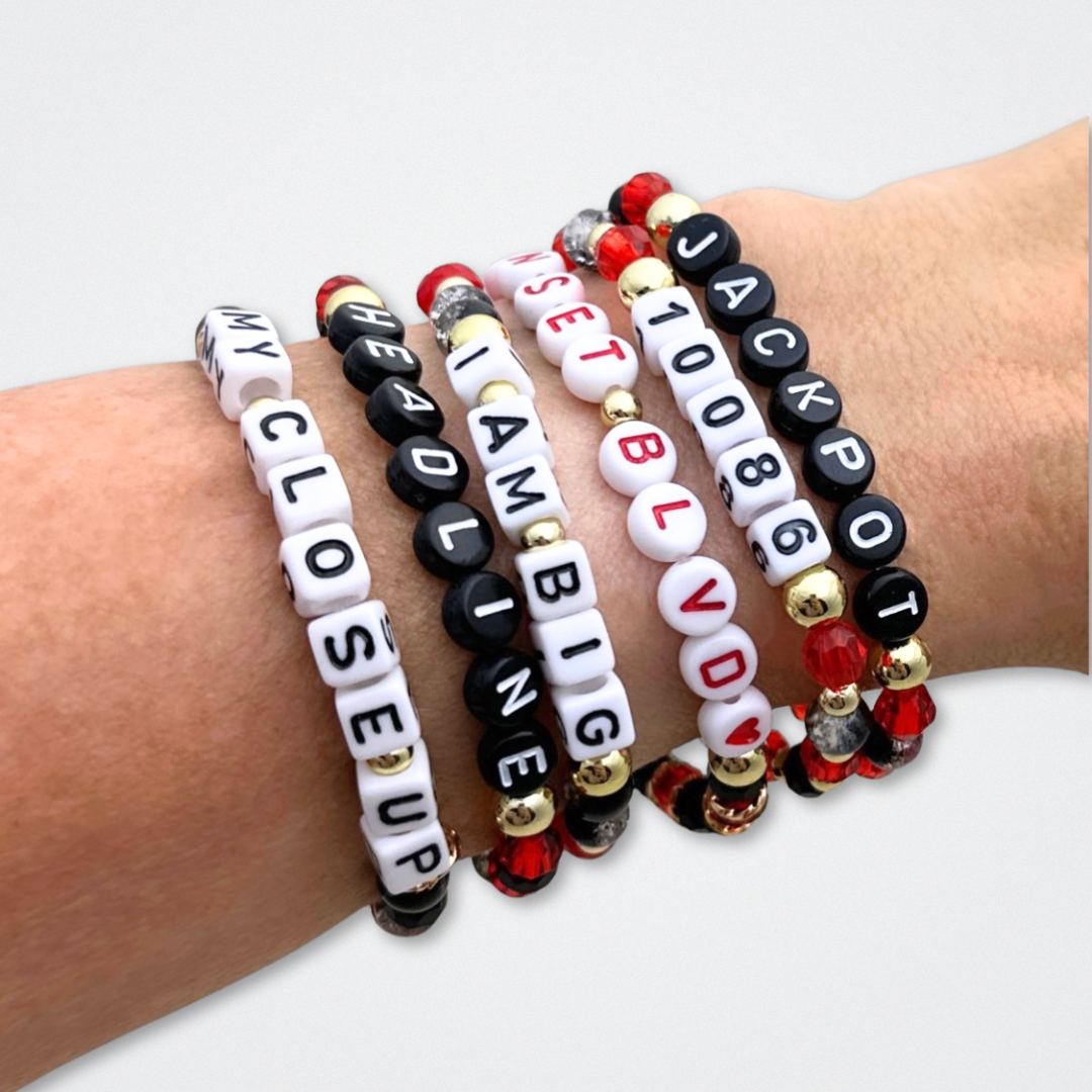 Broadway Stacks CLOSE-UP Collection. 6 stretch bracelets included in Stack. Red, black and gold colored beads. Letter beads that spell quotes. Gold star logo bead to remind you that you shine. Sunset Blvd fans. 
