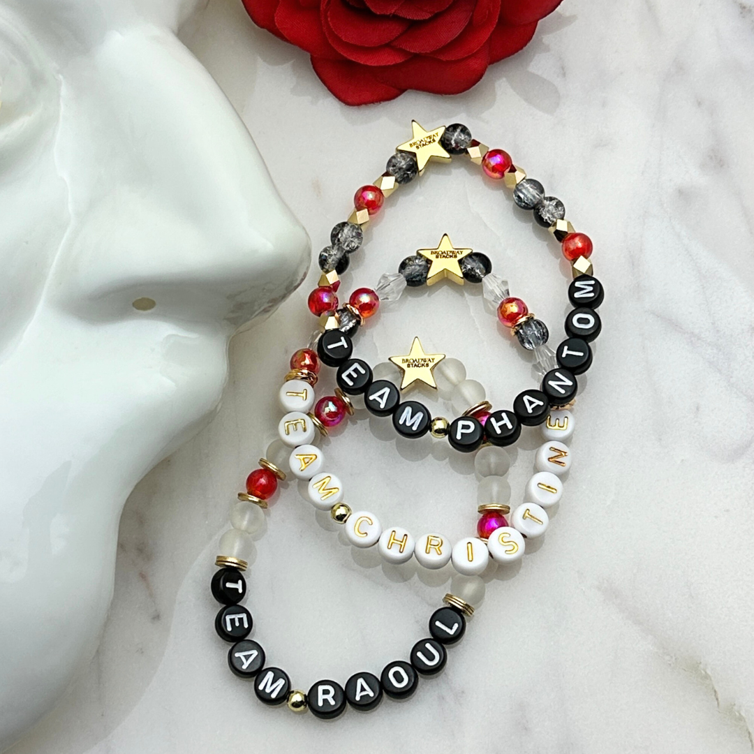 Broadway Stacks MASK collection. Team Phantom, Team Raoul, Team Christine letter bracelets. Stretch bracelet with red, black,  gold and beads. Broadway Stacks gold star logo bead.