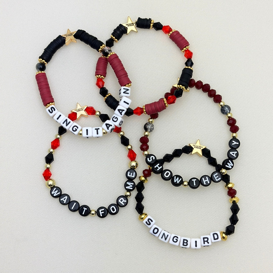 Broadway Stacks Underworld collection. 5 stretch bracelets included in Stack. Red, garnet, black and gold colored beads. Letter beads that spell quotes. Gold star logo bead to remind you that you shine.