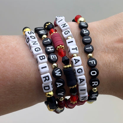 Broadway Stacks Underworld collection. 5 stretch bracelets included in Stack. Red, garnet, black and gold colored beads. Letter beads that spell quotes. Gold star logo bead to remind you that you shine.