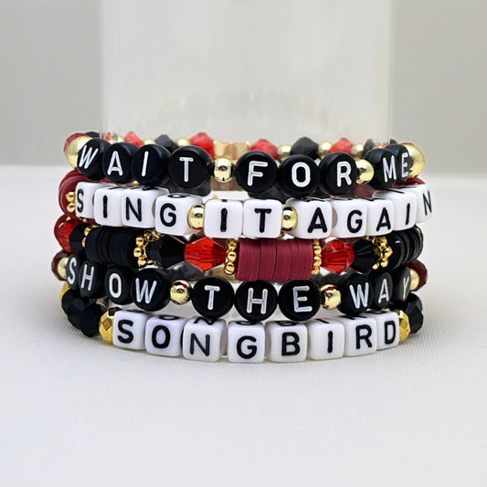 Broadway Stacks Underworld collection. 5 stretch bracelets included in Stack. Red, garnet, black and gold colored beads. Letter beads that spell quotes. Gold star logo bead to remind you that you shine.