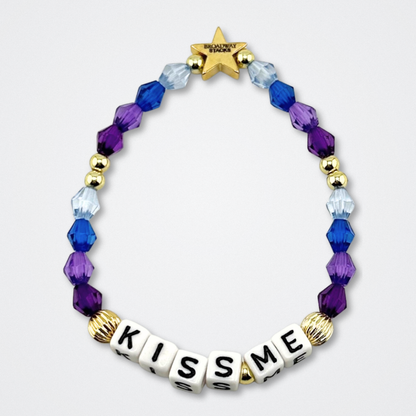 Broadway Stacks theatre-themed bracelet inspired by The Notebook Musical. Quote says KISS ME with blue and purple beads on a gray background. Signature star bead to remind you that You Shine!