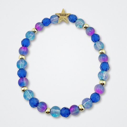 Broadway Stacks CAKE Collection. Bead bracelet with dark and light blue, purple and gold colored beads. Star logo bead to remind you that you shine. Two Strangers Carry a Cake Across New York fans.