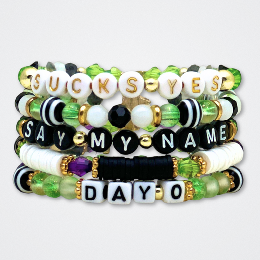 Broadway Stacks NETHERWORLD Collection. 5 stretch bracelets included in Stack. Green, black, purple, striped and gold colored beads. Letter beads that spell quotes. Gold star logo bead to remind you that You Shine. Beetlejuice fans. 
