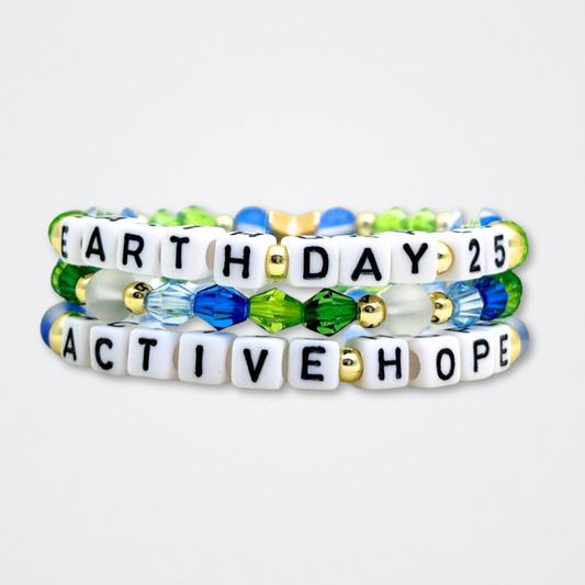 Earth Day Special Edition bracelet. Stack of 3 bracelets. Green, blue, white and gold beads. Letter beads that spell Earth Day 25 and Active Hope. Gold star logo bead to remind you that You Shine.