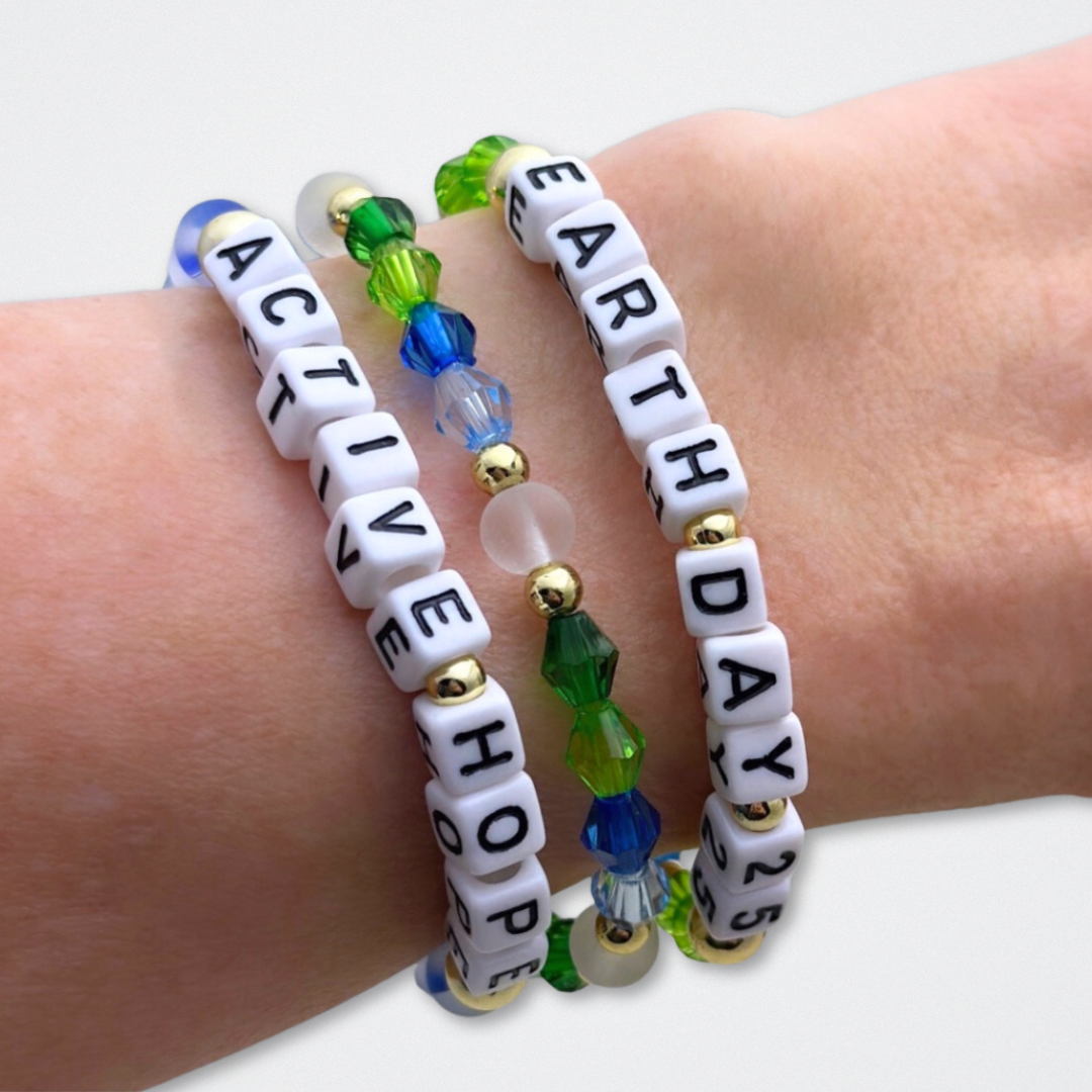 Earth Day Special Edition bracelet. Stack of 3 bracelets. Green, blue, white and gold beads. Letter beads that spell Earth Day 25 and Active Hope. Gold star logo bead to remind you that You Shine.