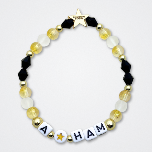 Broadway Stacks REVOLUTION Collection. 5 stretch bracelets included in Stack. Yellow, white, black and gold colored beads. Letter beads that spell quotes. Gold star logo bead to remind you that You Shine. Hamilton the Musical fans. 