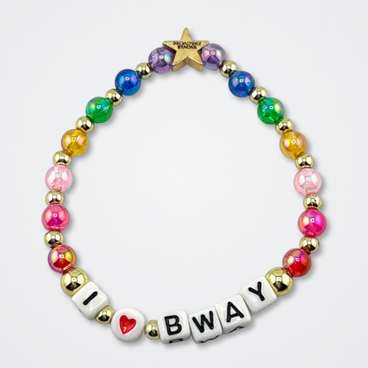 Broadway Stacks I love Bway bead bracelet displayed on a gray background. Rainbow color beads. Letter beads spell out quote. Signature star bead to remind you: YOU SHINE! 