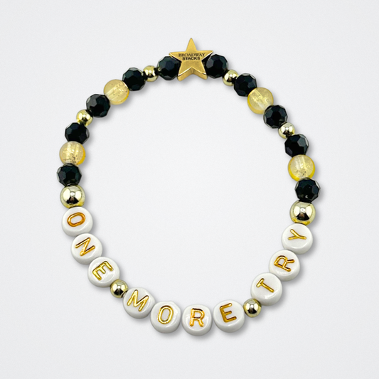 Broadway Stacks De Bois Band collection. Yellow, gold and black colored beads on bracelet on gray background. Letter beads that spell quotes. Broadway Stacks gold star logo bead to remind you that you shine. & Juliet the Musical fans.