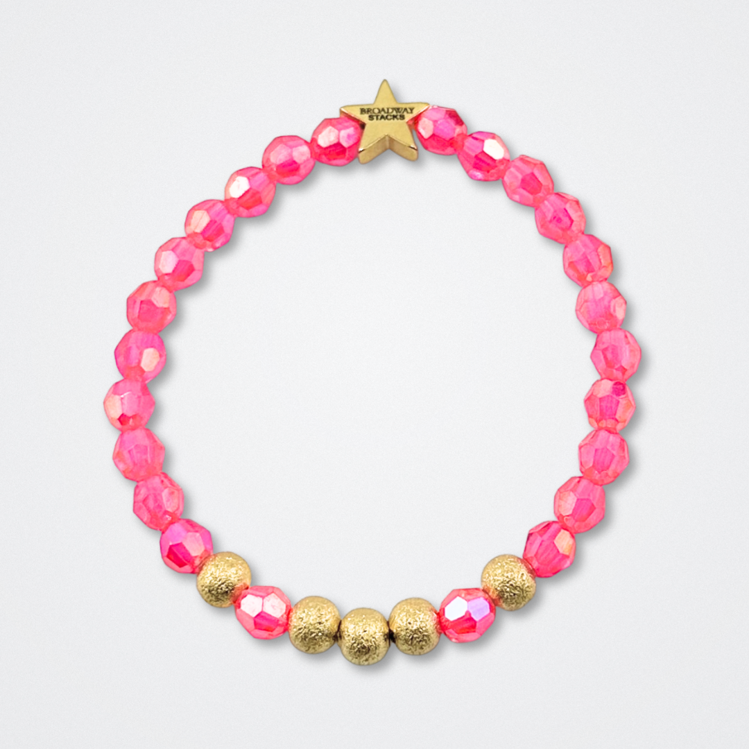 Broadway Stacks De Bois Band collection. Pink and gold colored beads on bracelets. Star logo bead to remind you that YOU SHINE! Background is gray. Inspired by & Juliet the Musical.