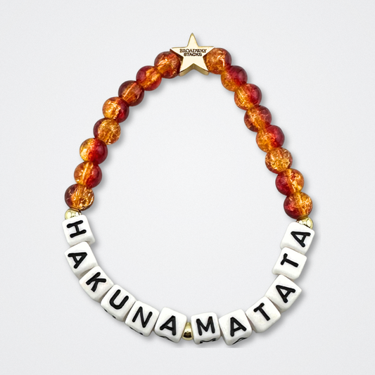 Broadway Stacks SAFARI collection. Red and yellow crackle beads and gold colored beads on bracelet on gray background. Letter beads that spell quotes. Star logo bead to remind you that YOU SHINE! The Lion King and theatre fans.