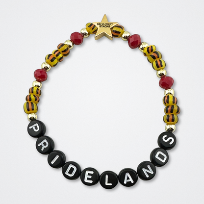 Broadway Stacks SAFARI collection. Red and animal print beads and gold colored beads on bracelet on gray background. Letter beads that spell quotes. Star logo bead to remind you that YOU SHINE! The Lion King and theatre fans.