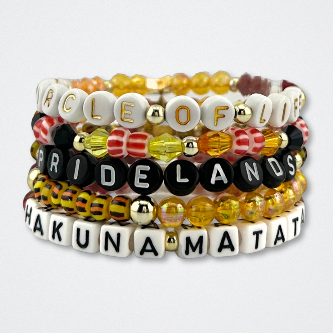 Broadway Stacks SAFARI collection.Yellow, orange, red, black, animal print and gold colored beads on bracelets. Bracelets stacked on gray background. The Lion King and theatre fans.