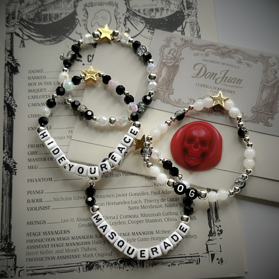 Broadway Stacks MASQUERADE Collection. 4 stretch bracelets included in Stack. Black, white and silver colored beads. Letter beads that spell quotes. Gold star logo bead to remind you that you shine. Phantom of the Opera and Masquerade NYC fans.