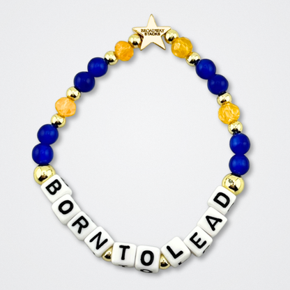 Broadway Stacks CONFIDENTIAL Collection. Born To Lead bracelet with blue, yellow and gold colored beads. Letter beads that spell quote. Star logo bead to remind you that you shine. Operation Mincemeat fans.