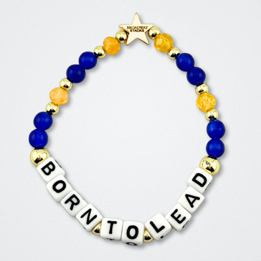 Broadway Stacks CONFIDENTIAL Collection. Born To Lead bracelet with blue, yellow and gold colored beads. Letter beads that spell quote. Star logo bead to remind you that you shine. Operation Mincemeat fans.