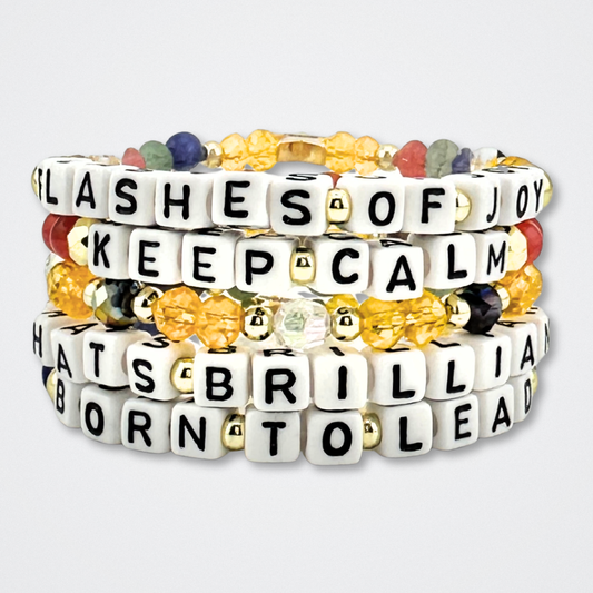 Broadway Stacks CONFIDENTIAL Collection. 5 stretch bracelets included in Stack. Black, white, red, blue, green, yellow and gold colored beads. Letter beads that spell quotes. Star logo bead to remind you that you shine. Operation Mincemeat fans.