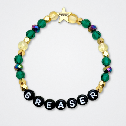 Broadway Stacks STAY GOLD collection. Stretch bracelets included in Stack. Gold, yellow, green and grey colored beads. Letter beads that have show quote or name. Broadway Stacks gold star logo bead to remind you that You Shine. The Outsiders the Musical fans.
