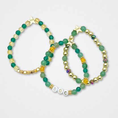 Broadway Stacks STAY GOLD collection. Stretch bracelets included in Stack. Gold, yellow, green and grey colored beads. Letter beads that have show quote or name. Broadway Stacks gold star logo bead to remind you that You Shine. The Outsiders the Musical fans.