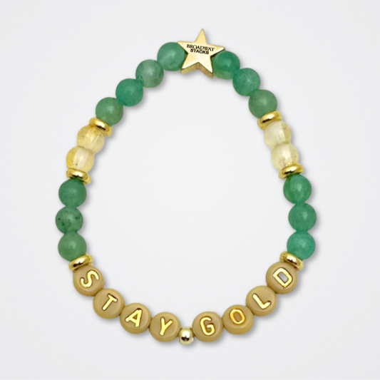Broadway Stacks STAY GOLD collection. Stretch bracelets included in Stack. Gold, yellow, green and grey colored beads. Letter beads that have show quote or name. Broadway Stacks gold star logo bead to remind you that You Shine. The Outsiders the Musical fans.