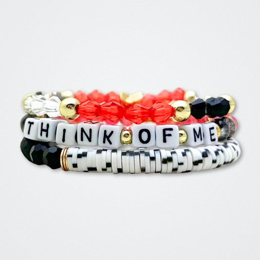 Broadway Stacks MASK collection. Bead bracelets included in Stack. Red, black, white and gold colored beads. Letter beads that spell quotes. Team Phantom, Team Christine, Team Raoul. Gold star logo bead to remind you that You Shine. Phantom of the Opera and Masquerade fans.