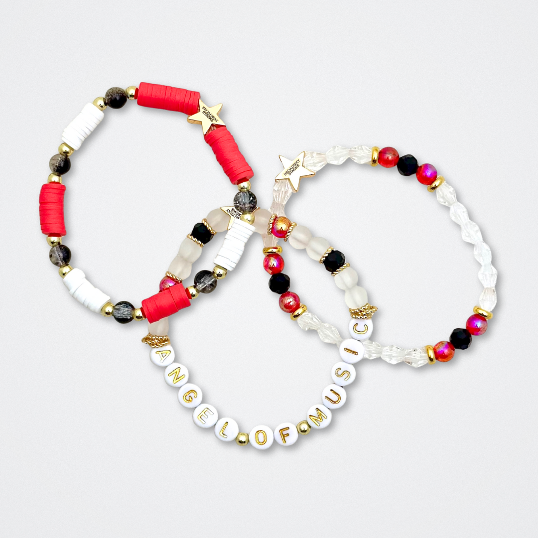 Broadway Stacks MASK collection. Bead bracelets included in Stack. Red, black, white and gold colored beads. Letter beads that spell quotes. Team Phantom, Team Christine, Team Raoul. Gold star logo bead to remind you that You Shine. Phantom of the Opera and Masquerade fans.