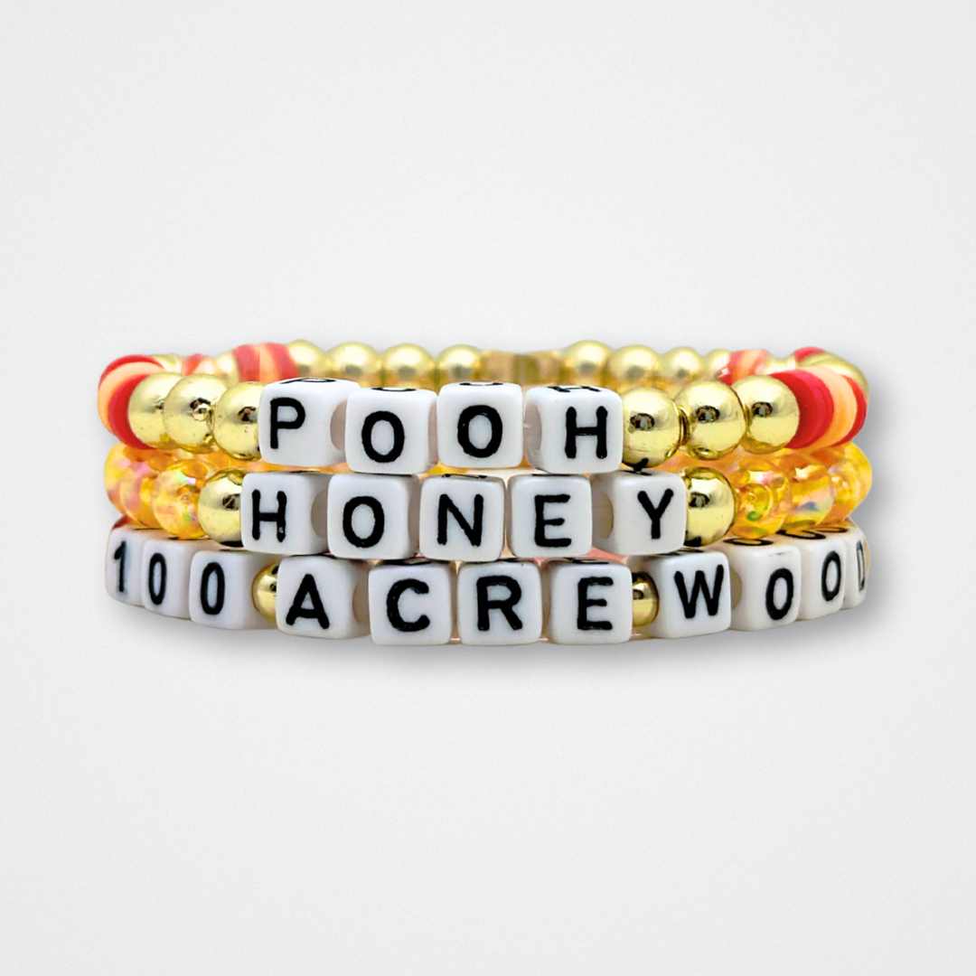 Broadway Stacks HONEY Collection. 3 stretch bracelets included in Stack. Red, yellow and gold colored beads. Letter beads that spell quotes. Gold star logo bead to remind you that You Shine. Winnie the Pooh fans.