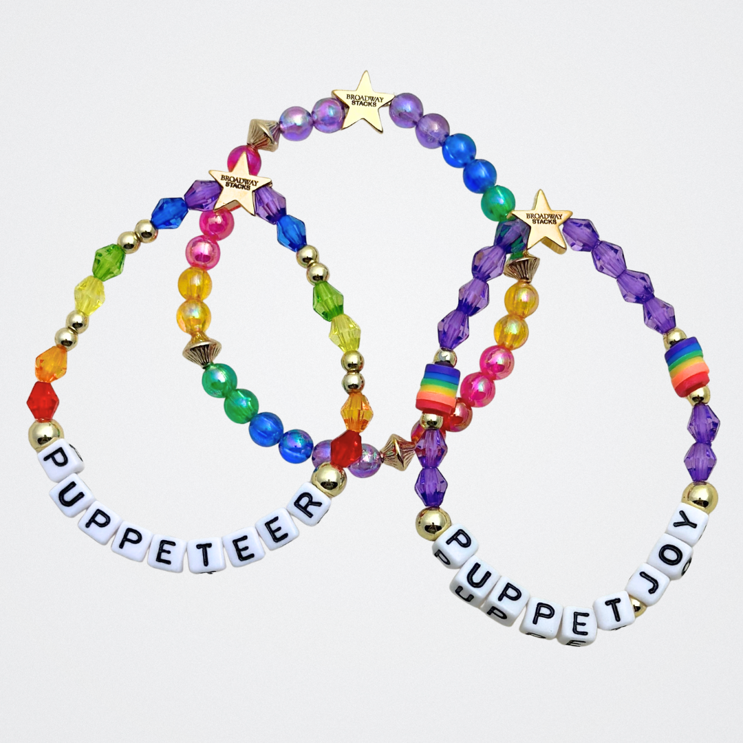 Broadway Stacks PUPPETRY Collection Special Edition bracelet. Stack of 3 bracelets. Rainbow and gold beads. Letter beads that spell Puppeteer and Puppet Joy. Gold star logo bead to remind you that You Shine. 