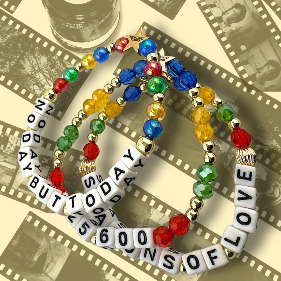 Broadway Stacks theatre-themed bracelets inspired by RENT the Musical. Three bracelets with quotes SEASONS OF LOVE, 525,600 and NO DAY BUT TODAY with red, green, yellow and blue beads on a background of 35mm film with yellow overlay.