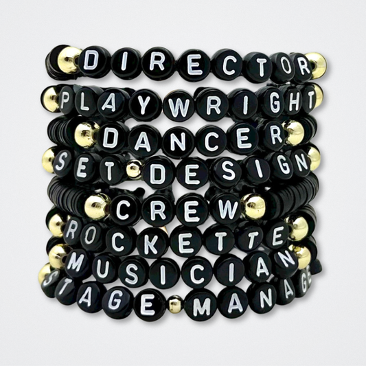 Set of black bracelets with white lettering on a white background. Broadway Stacks theatre-themed Spotlight bracelets highlighting ALL theater roles. Because everyone deserves to shine.