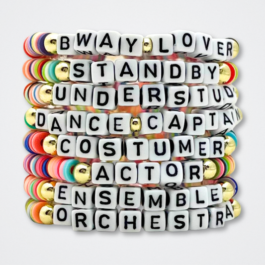 Stack of colorful bracelets with letter beads on a white background. Broadway Stacks theatre-themed Spotlight bracelets highlighting ALL theater roles. Because everyone deserves to shine.