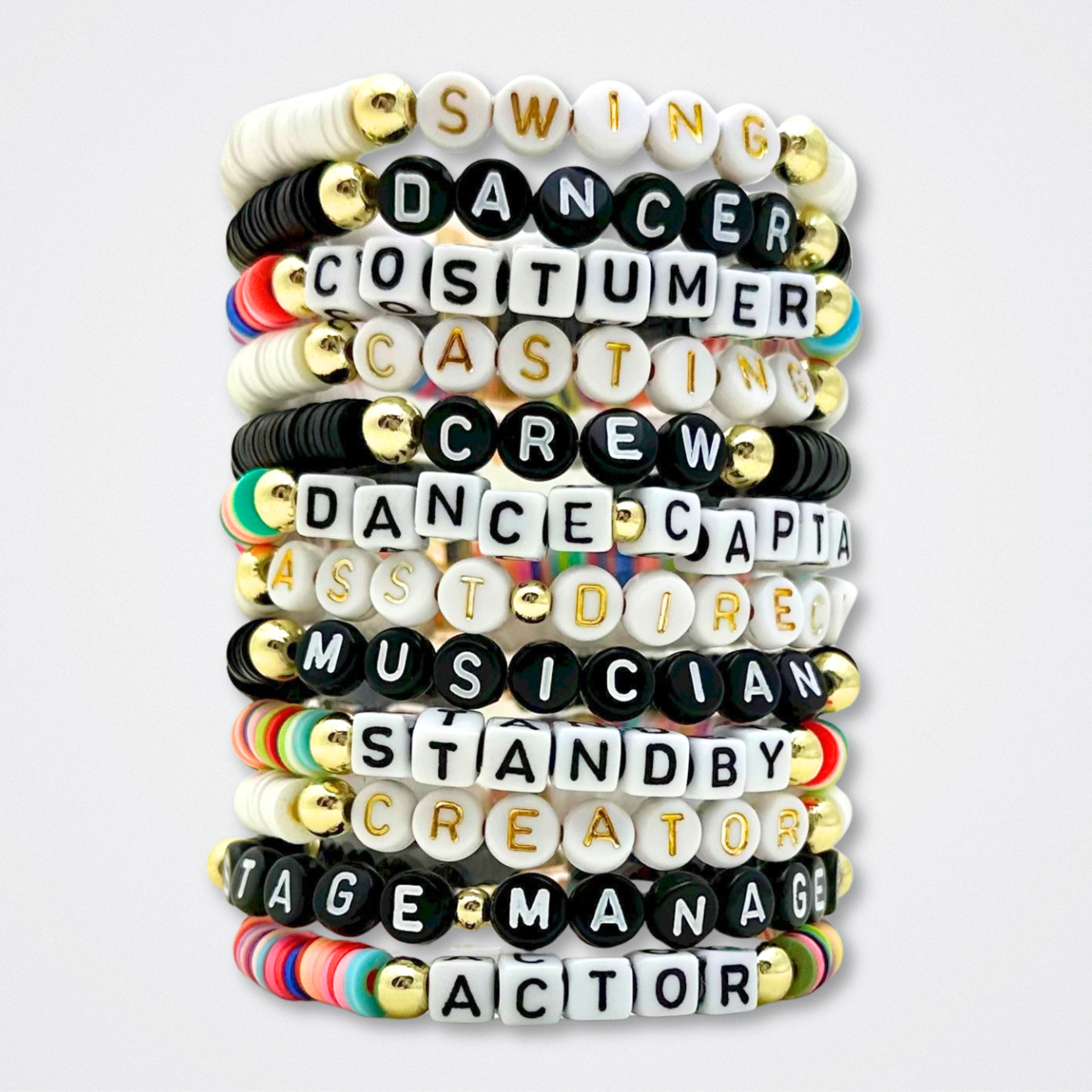 Stack of letter heishi bracelets with various theater roles on a white background. Broadway Stacks theatre-themed Spotlight bracelets highlighting ALL theater roles. Because everyone deserves to shine.