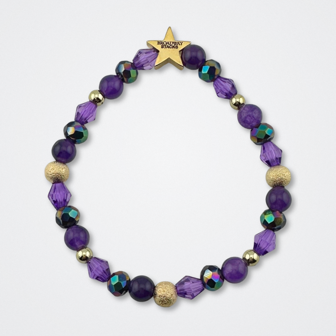 Variety of purple beads on bracelet on a gray background. Inspired by he character STAR in The Lost Boys Musical. Broadway Stacks VAMPIRE Collection. Gold star logo bead to remind you that you shine. 