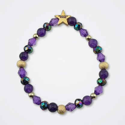 Variety of purple beads on bracelet on a gray background. Inspired by he character STAR in The Lost Boys Musical. Broadway Stacks VAMPIRE Collection. Gold star logo bead to remind you that you shine. 