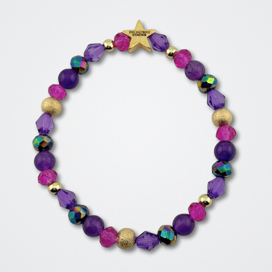 Variety of purple and pink beads on bracelet on a gray background. Inspired by he character STAR in The Lost Boys Musical. Broadway Stacks VAMPIRE Collection. Gold star logo bead to remind you that you shine. 
