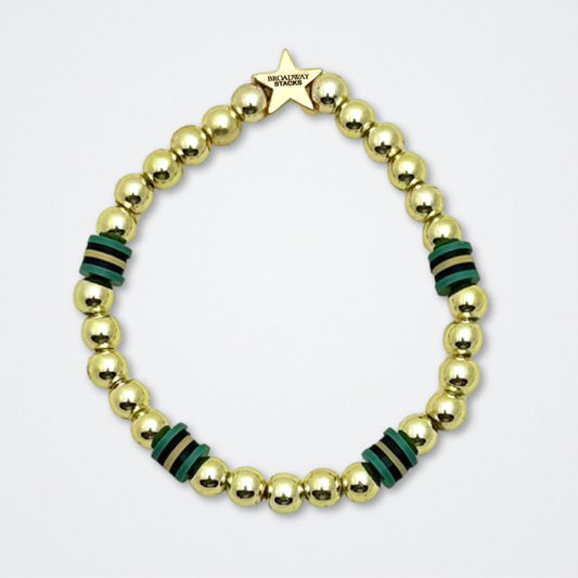 Broadway Stacks STAY GOLD bracelet inspired by The Outsiders Musical. Dark green and gold beads. Logo star bead to remind you that YOU SHINE. Displayed on a gray background.