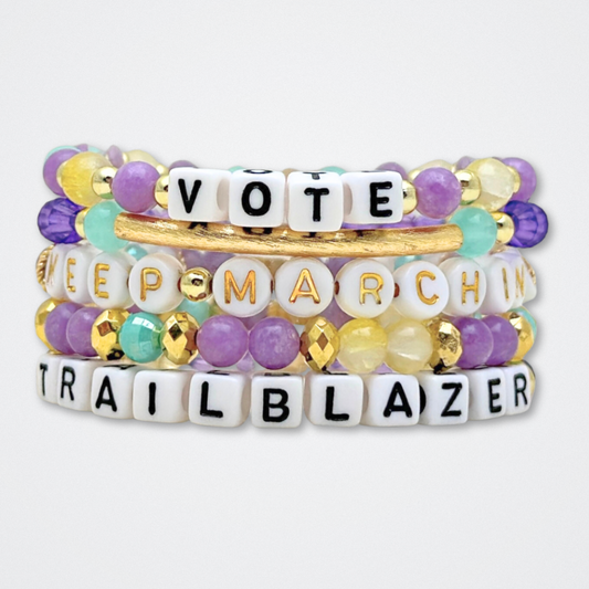 Broadway Stacks CAMPAIGN Collection. 5 stretch bracelets included in Stack. Purple, yellow, teal and gold colored beads. Letter beads that spell quotes. Gold star logo bead to remind you that you shine. Suffs fans. 