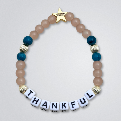 Broadway Stacks SAILOR Collection. 5 stretch bracelets included in Stack. Teal, green, blue and gold colored beads. Letter beads that spell quotes. Swept Away the Musical. Gold star logo bead to remind you that you shine.