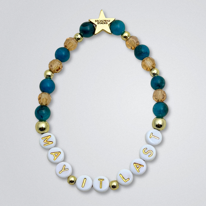 Broadway Stacks SAILOR Collection. 5 stretch bracelets included in Stack. Teal, green, blue and gold colored beads. Letter beads that spell quotes. Swept Away the Musical. Gold star logo bead to remind you that you shine.