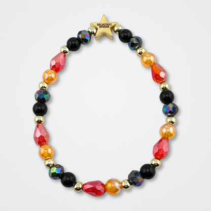 Black, red, orange and gold colored bead bracelet on a gray background. Broadway Stacks VAMPIRE Collection. Gold star logo bead to remind you that you shine. Inspired by The Lost Boys Musical.