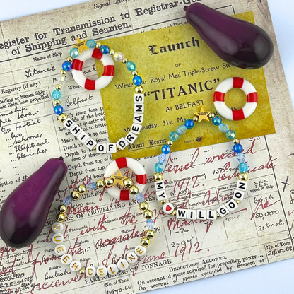 Three bead bracelets with nautical-themed accessories and mini eggplants on a document background. Part of the Broadway Stacks UNSINKABLE Collection. Inspired by Titanique the Musical.