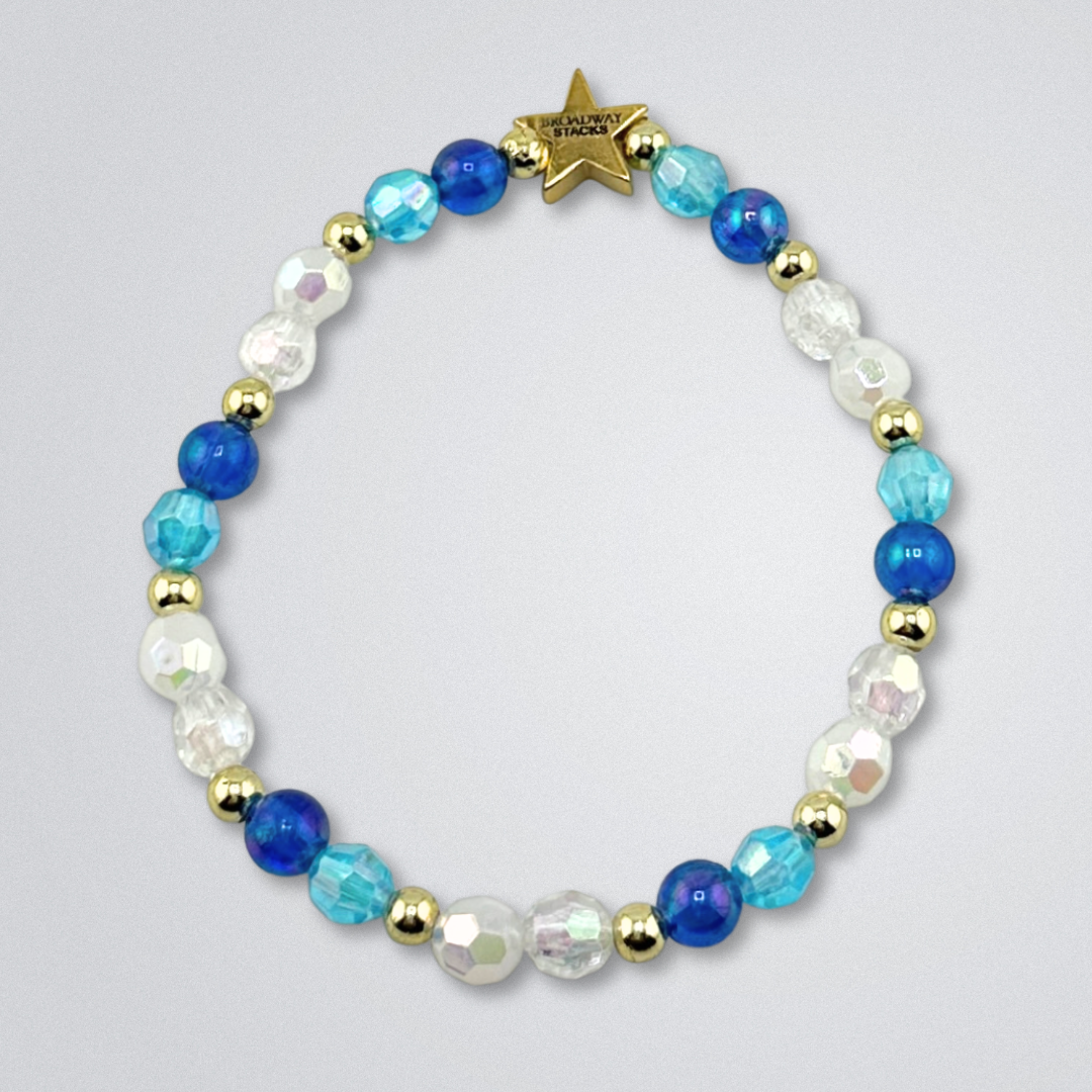Bead bracelet on a gray background, part of the Broadway Stacks UNSINKABLE Collection. Blues, clear and gold colored beads. Gold star logo bead to remind you that you shine. Inspired by Titanique the Musical.