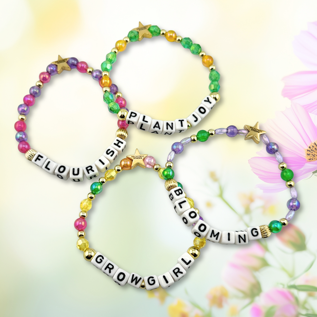 Broadway Stacks GARDEN bracelets. Green, yellow, pink, purple and gold color bead jewelry displayed on a floral background.