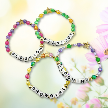 Broadway Stacks GARDEN bracelets. Green, yellow, pink, purple and gold color bead jewelry displayed on a floral background.