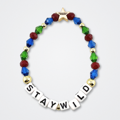 Broadway Stacks STAY WILD bead bracelet. Green, blue, dark red and gold color beads on a gray background.