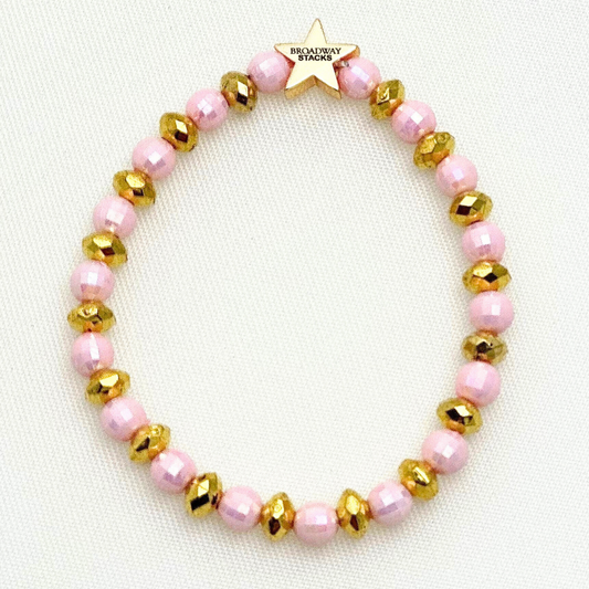 Broadway Stacks Witch collection. 3 stretch bracelets included in Stack. Greens, pinks, black and gold colored beads. Letter beads that spell Wicked. Gold star logo bead on every bracelet. 