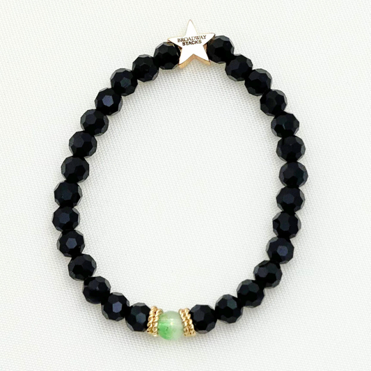 Broadway Stacks Witch collection. 3 stretch bracelets included in Stack. Greens, pinks, black and gold colored beads. Letter beads that spell Wicked. Gold star logo bead on every bracelet. 