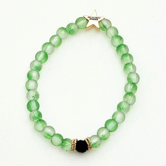 Broadway Stacks Witch collection. 3 stretch bracelets included in Stack. Greens, pinks, black and gold colored beads. Letter beads that spell Wicked. Gold star logo bead on every bracelet. 